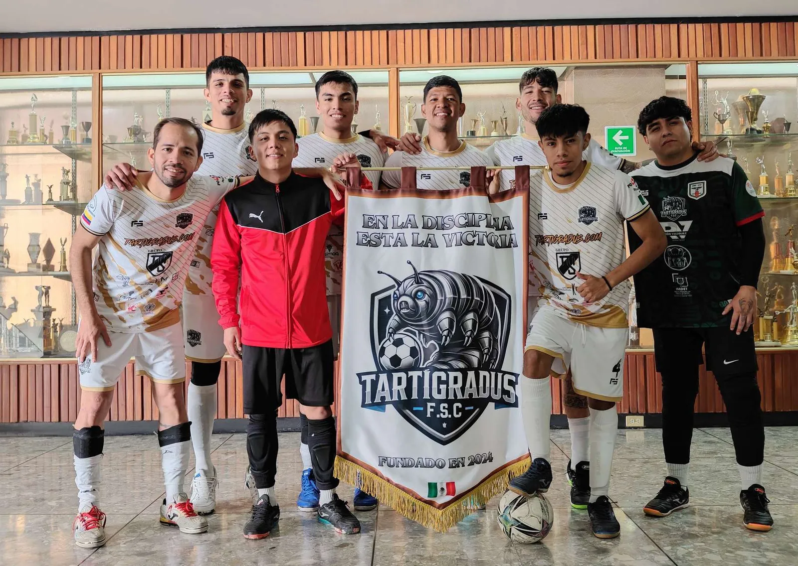 Plantel con el banderín «En la disciplina está la victoria»