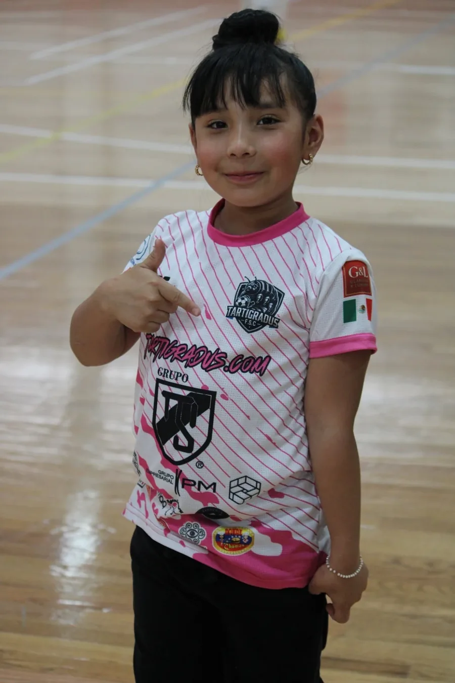 Niña de Tartígradus Kids con el uniforme del club en la duela del Gimnasio G2