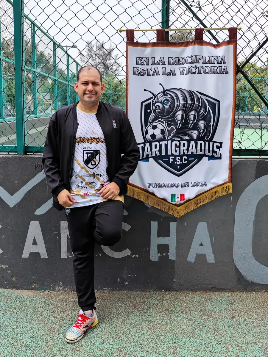 Alberto Gil, presidente de Tartígradus F.S.C., junto al banderín del club