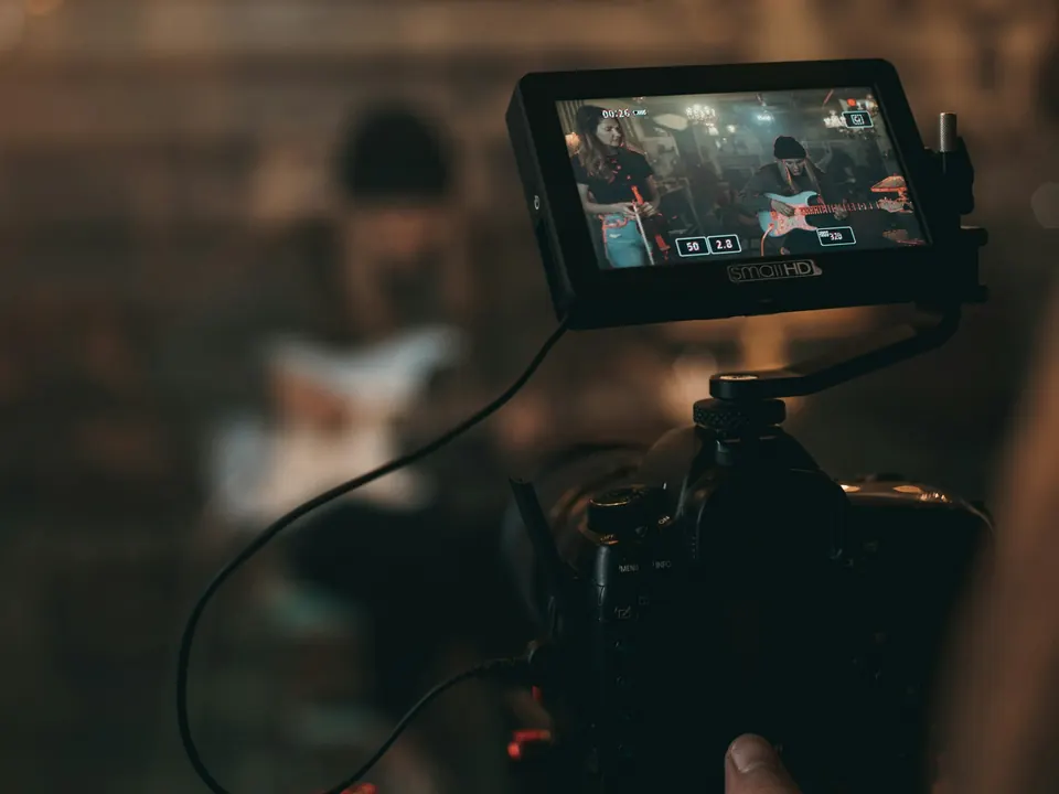 Cámara con monitor grabando a un músico