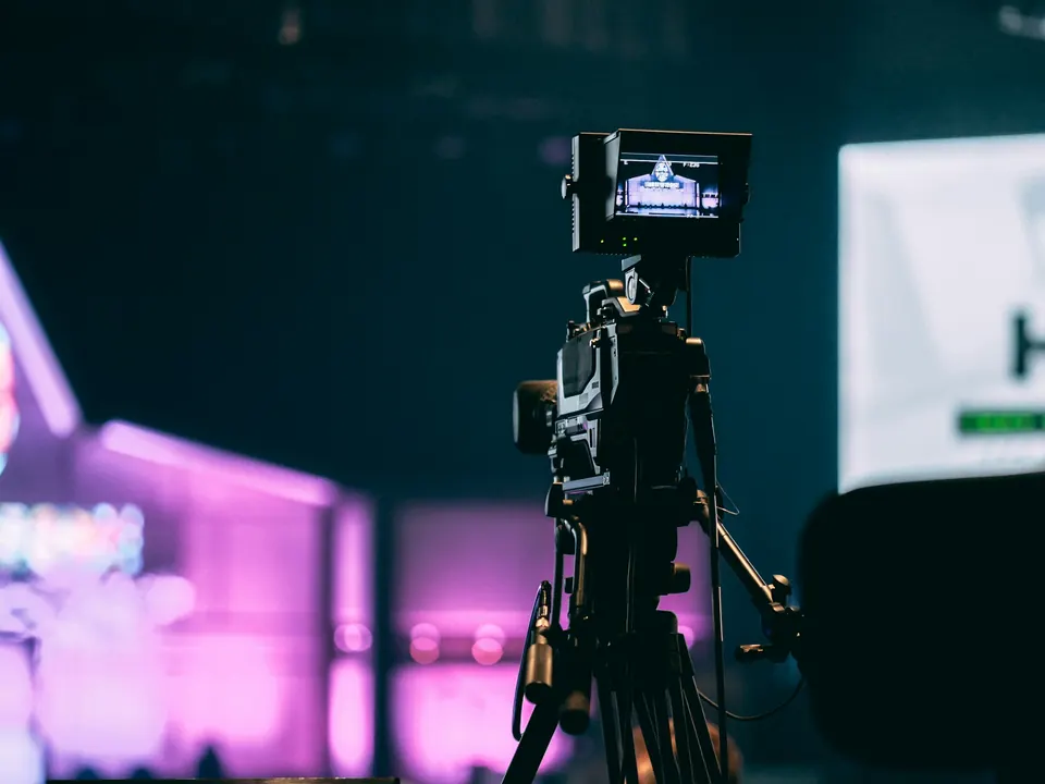 Cámara de video en tripié con monitor en un evento